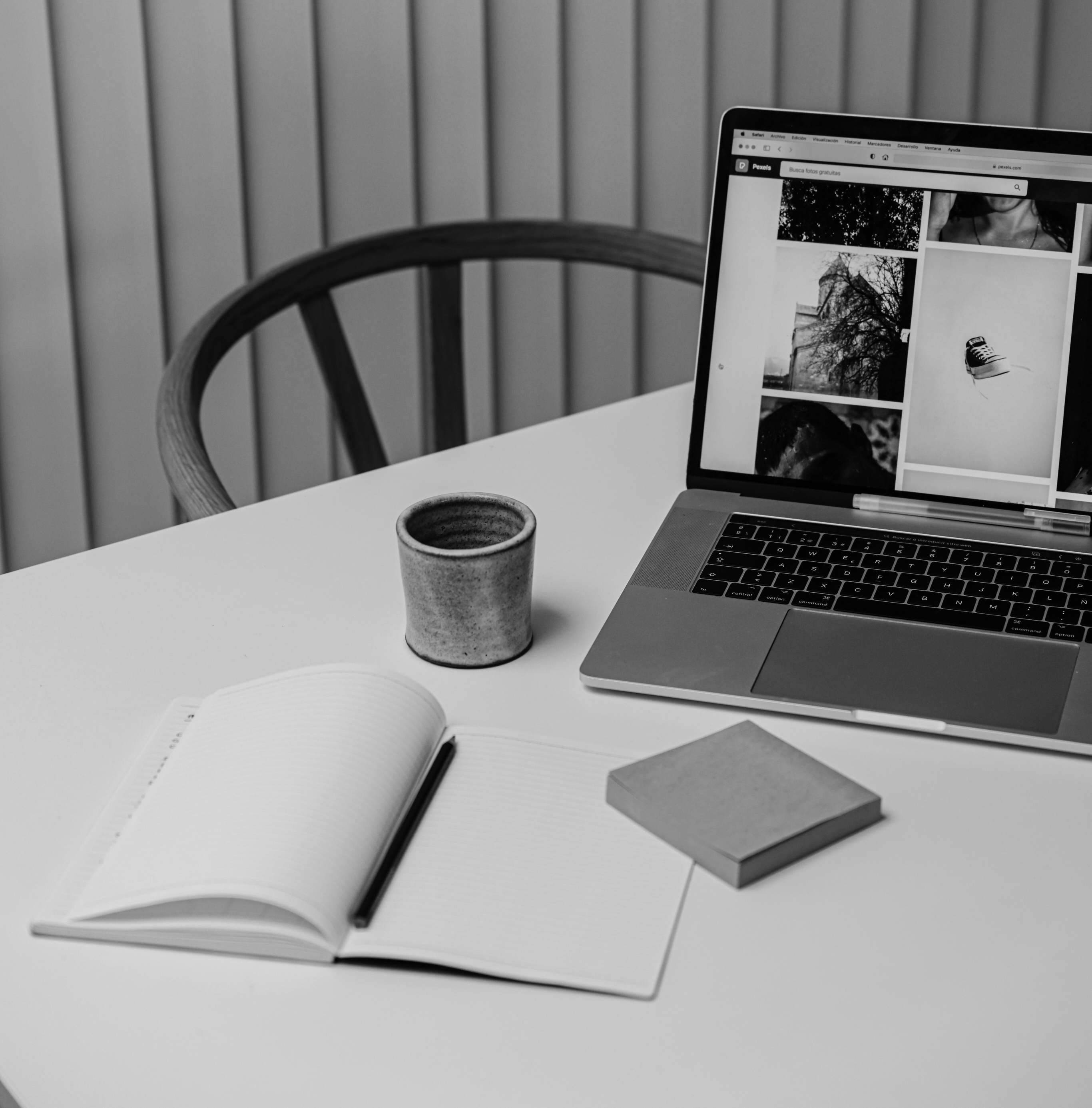 Mesa de trabajo con Macbook, taza y libreta.